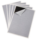 A pack of 5 replacement sticky glue boards for fly traps, with a part of one board showing adhesive side up.